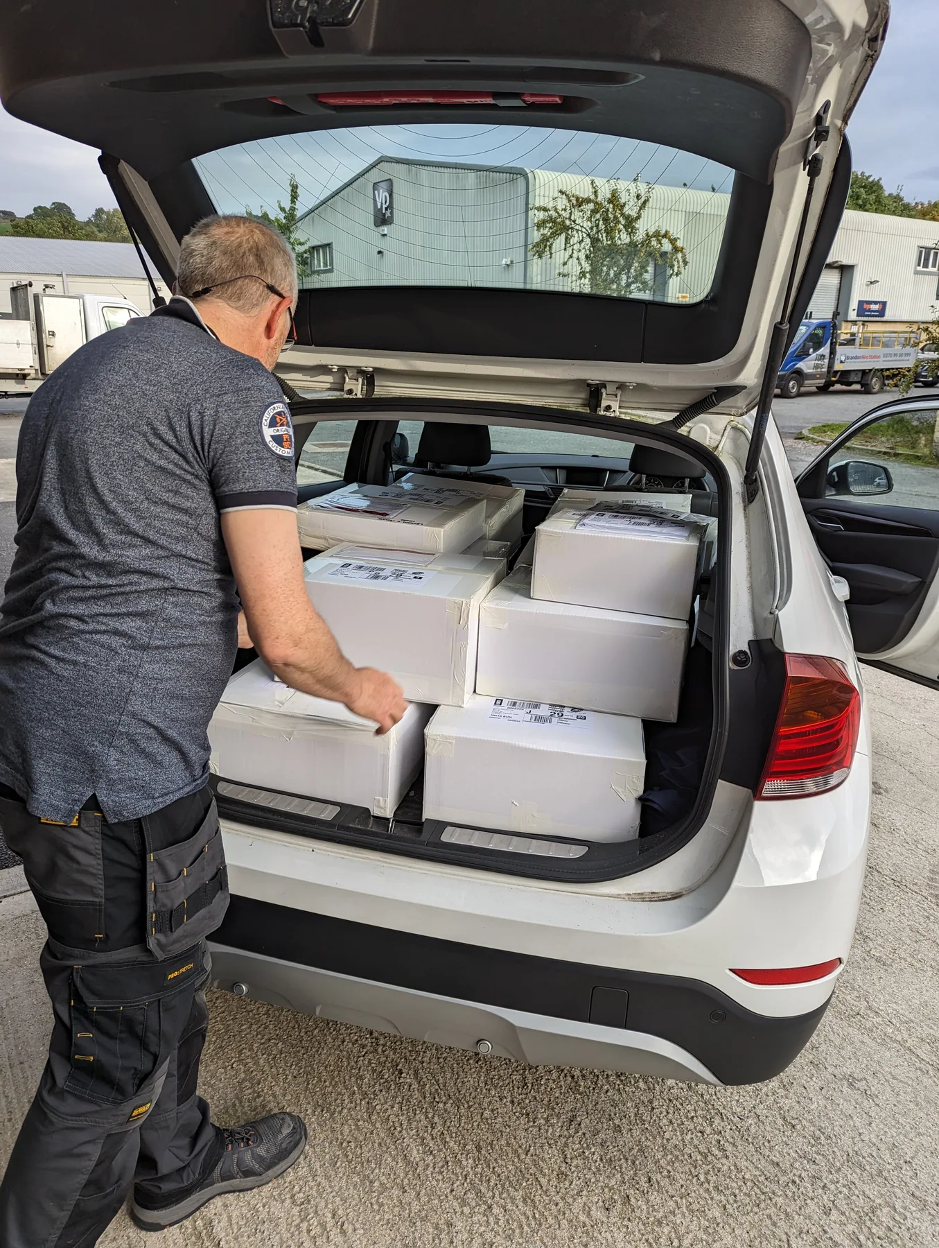 Real Northern Labels cartons being loaded into a car