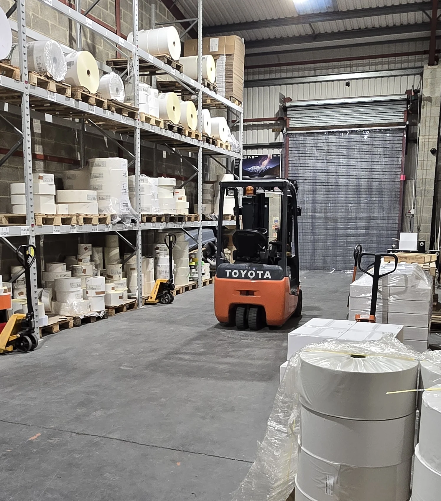 Genuine Northern Labels stock area with stocked materials and forklift